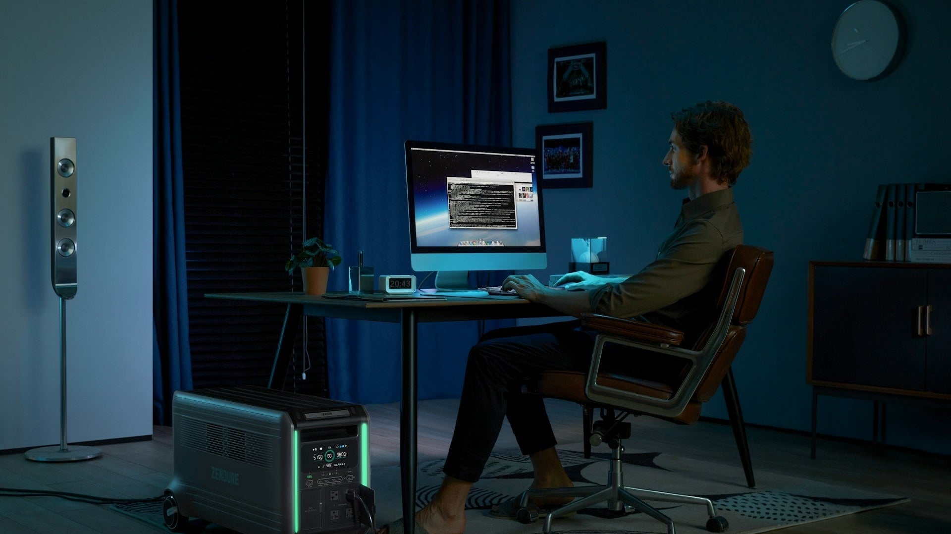A man sitting at a desk in front of a computer, demonstrating correct posture when sitting at a computer with a straight back and relaxed shoulders.