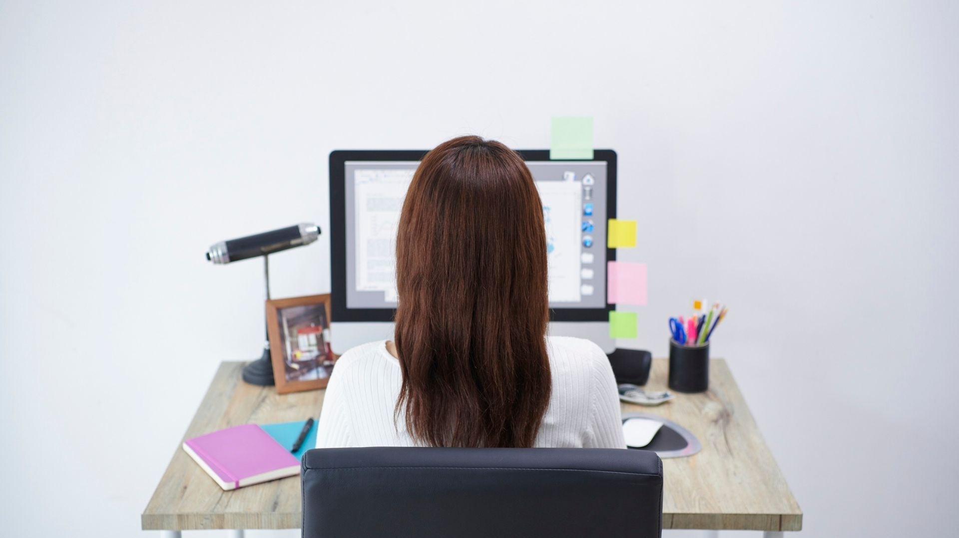 Person sitting at a desk with relaxed shoulders and straight posture, demonstrating proper shoulder posture while working at a computer.