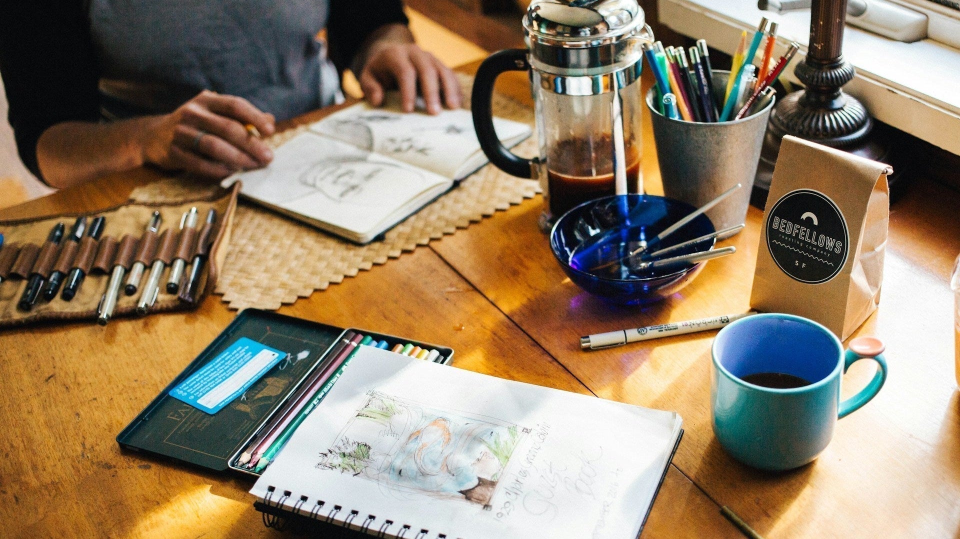 person holding book with sketch
