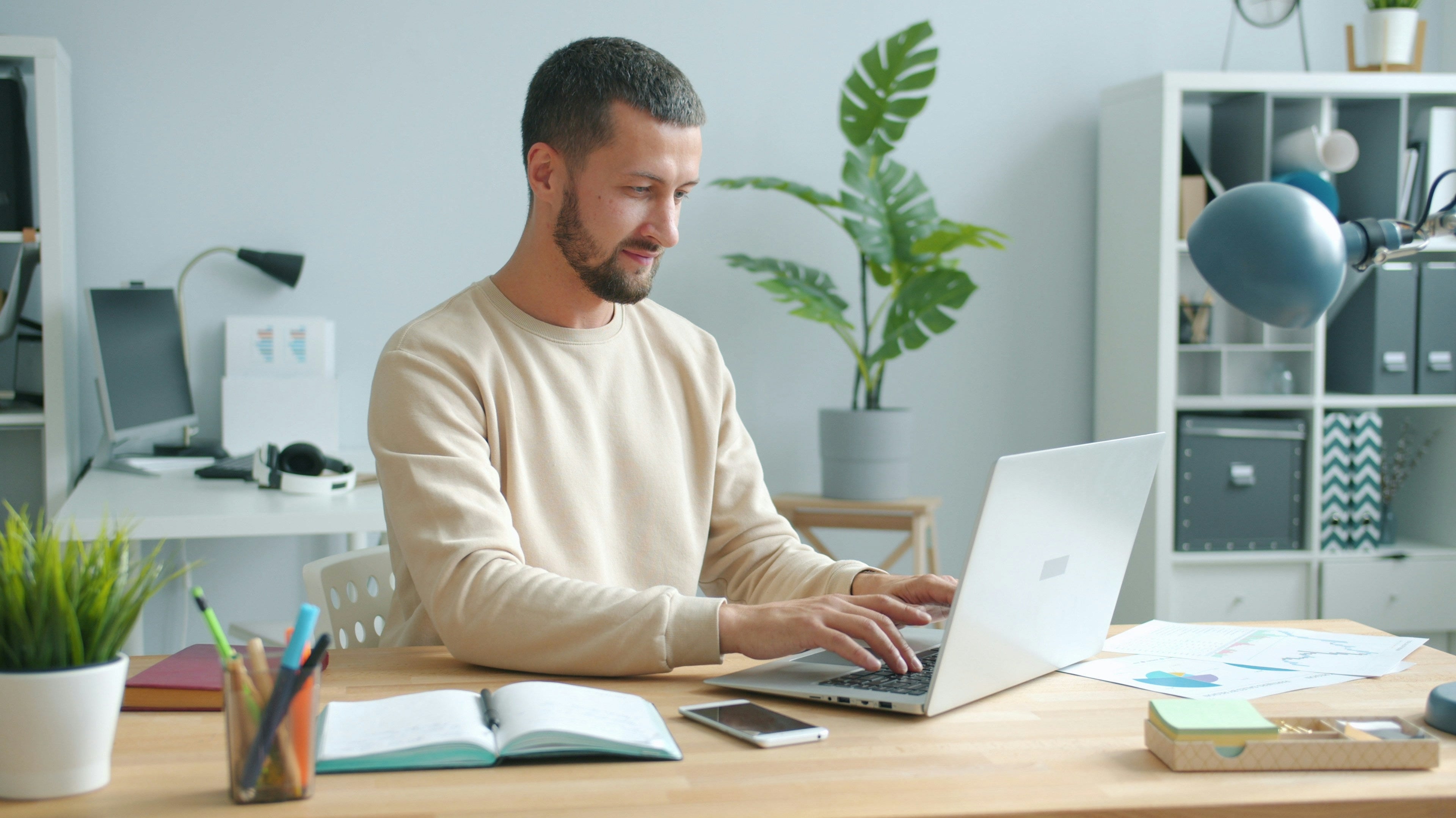 A man working at his desk with focus and good posture, representing efficiency at workplace through smart and productive work habits.