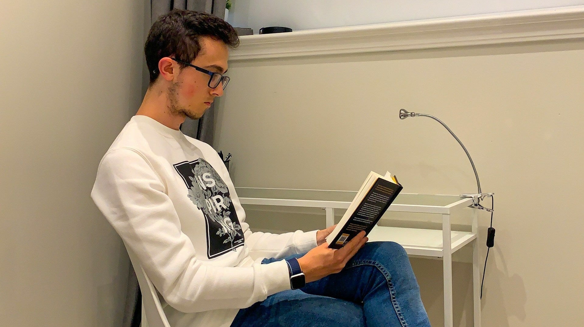 Does posture affect learning? A man reading a book in a corner sitting in a modern-looking chair. Image by Matt Lillywhite via www.unsplash.com