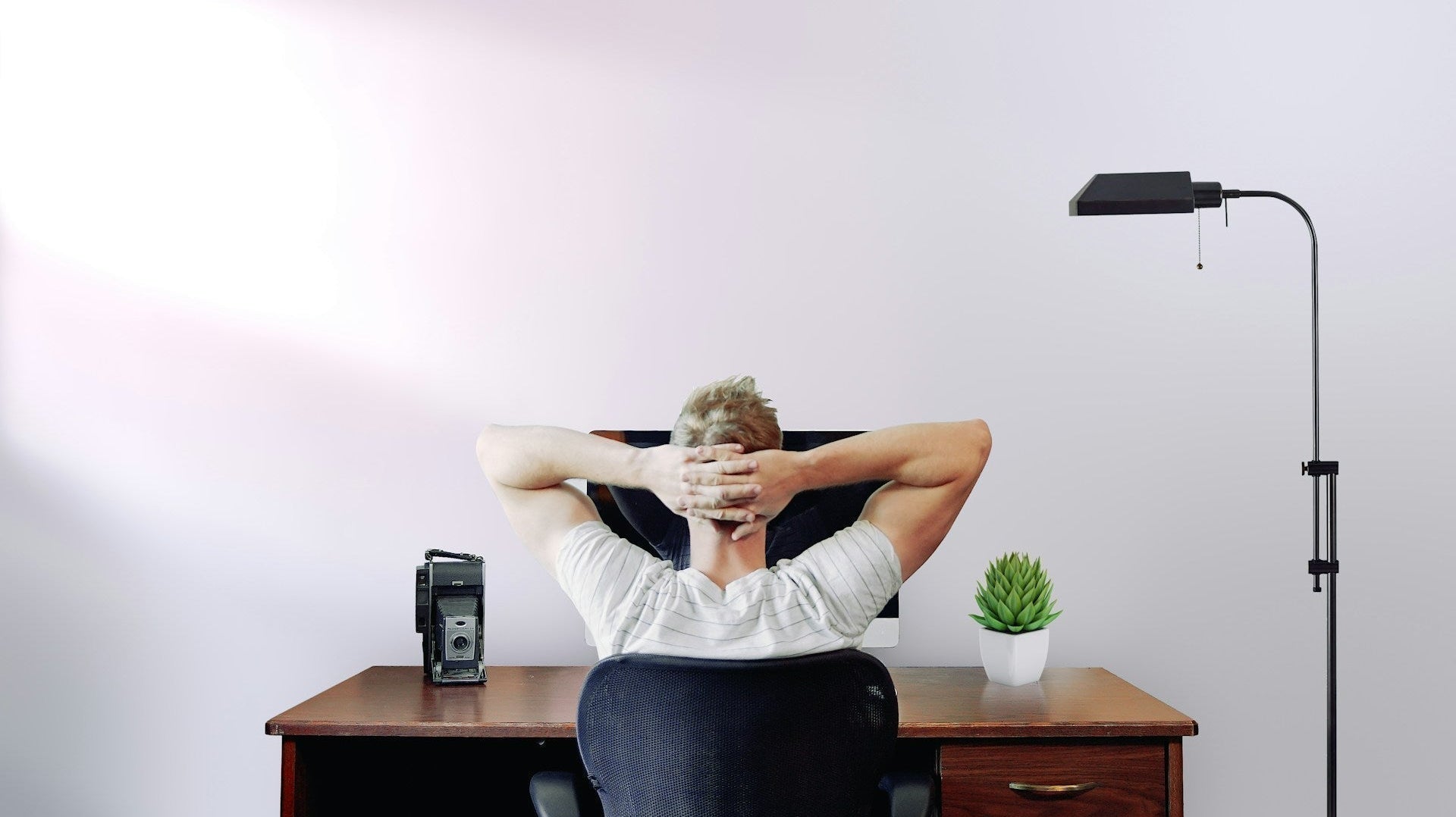 Man working contemplatively with good lighting in his home office with minimalist setting. Image by Jason Strull via www.unsplash.com