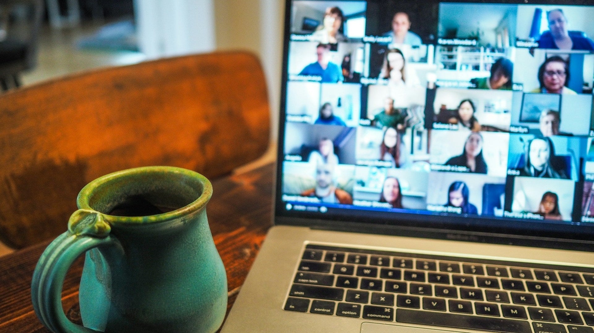 Remote team members in a Zoom meeting with coffee on the side, boosting work productivity from home. Photo by: Chris Montgomery via Unsplash