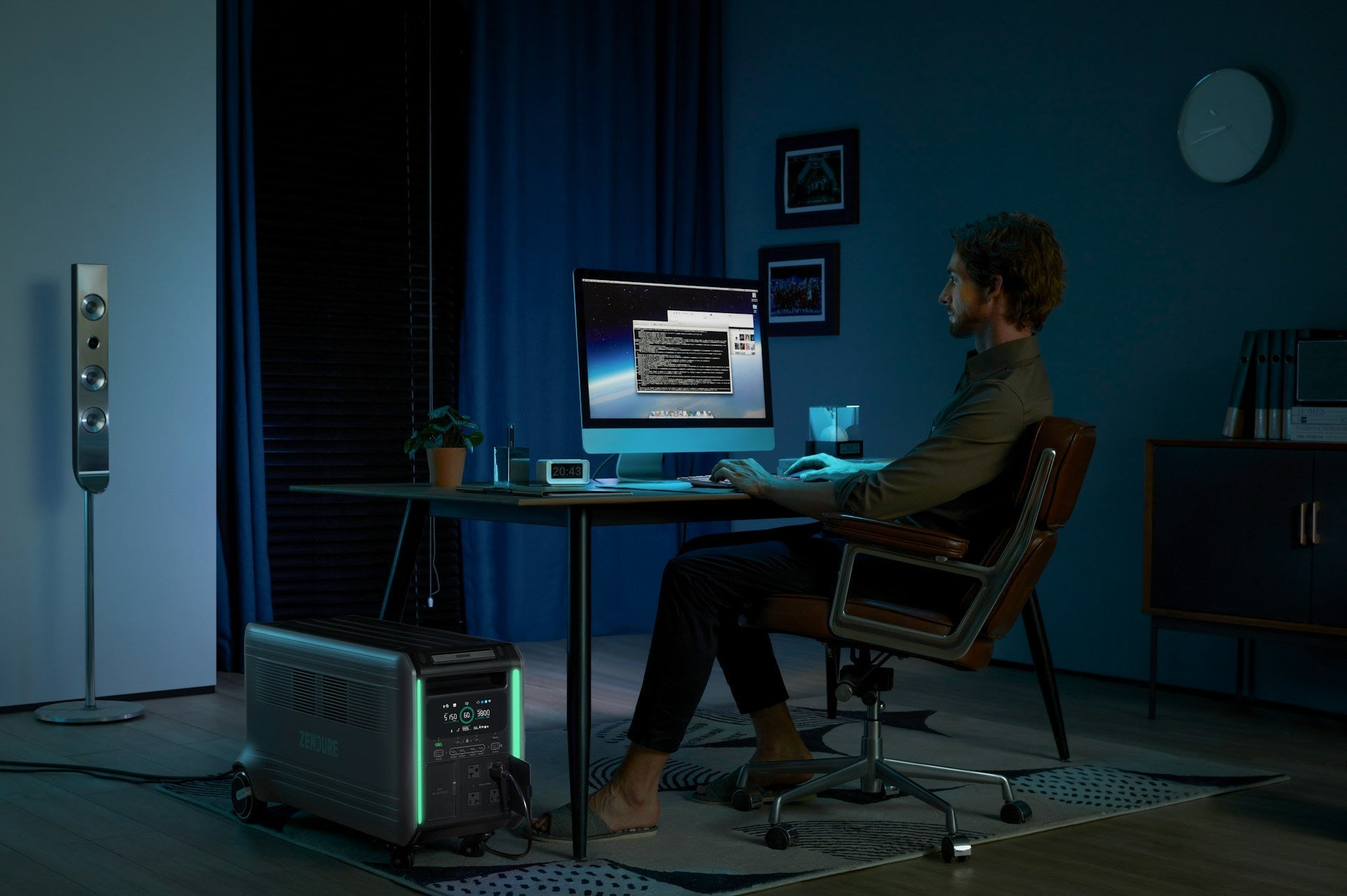 A man sitting at a desk in front of a computer, demonstrating correct posture when sitting at a computer with a straight back and relaxed shoulders.