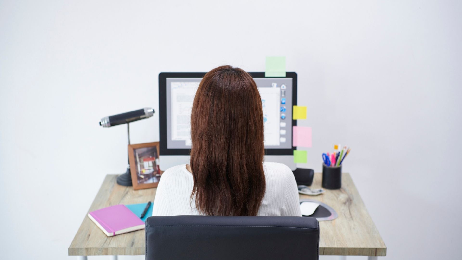 Person sitting at a desk with relaxed shoulders and straight posture, demonstrating proper shoulder posture while working at a computer.
