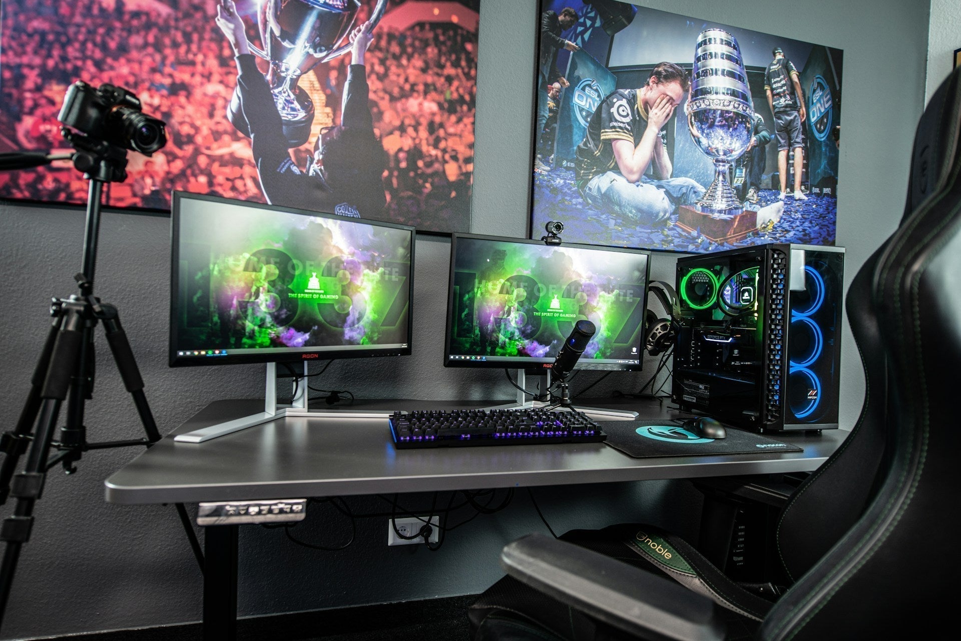 Gaming setup decorations with dual monitors, RGB PC, microphone, wall art, and chair creating an immersive and stylish gaming space. Image by ELLA DON via www.unsplash.com