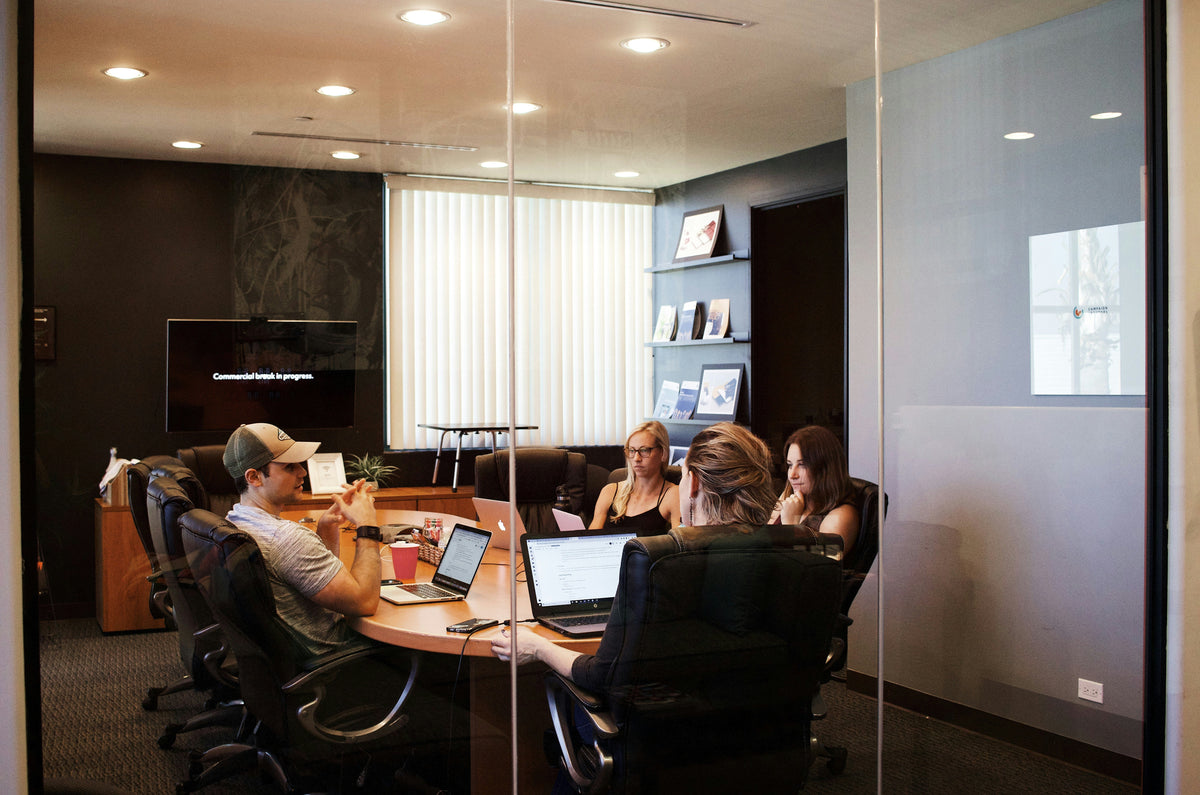 people sitting near table with laptop computer, talking about hybrid working arrangement. Image by Campaign Creators via www.unsplash.com