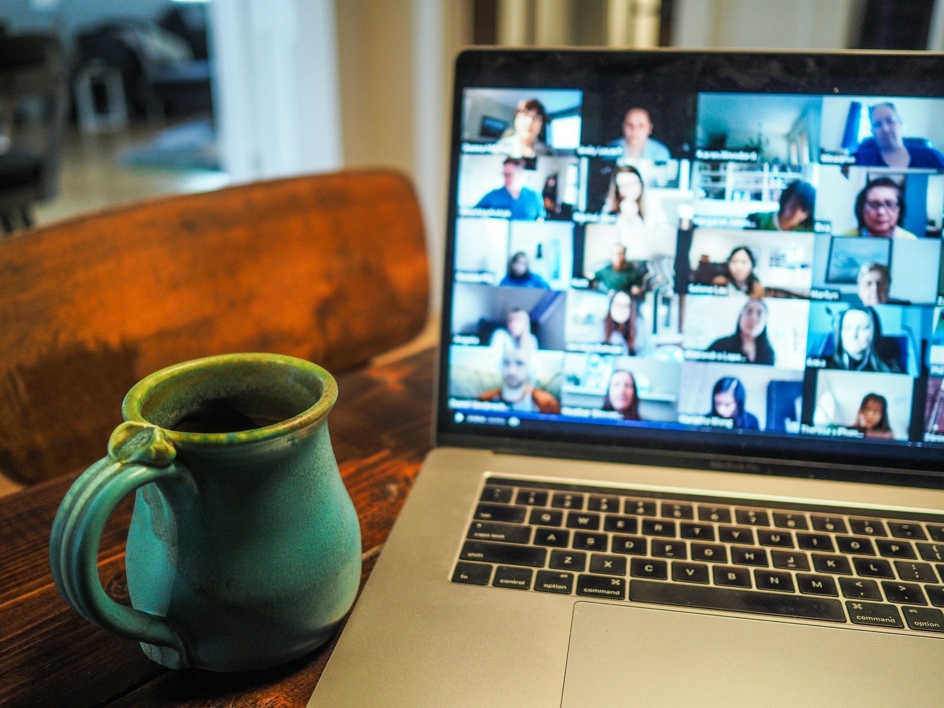 Remote team members in a Zoom meeting with coffee on the side, boosting work productivity from home. Photo by: Chris Montgomery via Unsplash