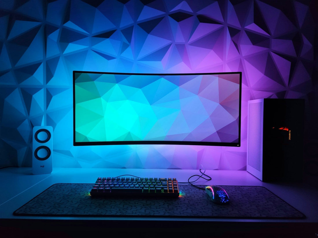A clean and modern gaming desk with RGB-lit keyboard and mouse, featuring a curved monitor and ambient lighting-perfect for those seeking simple gaming setup ideas.