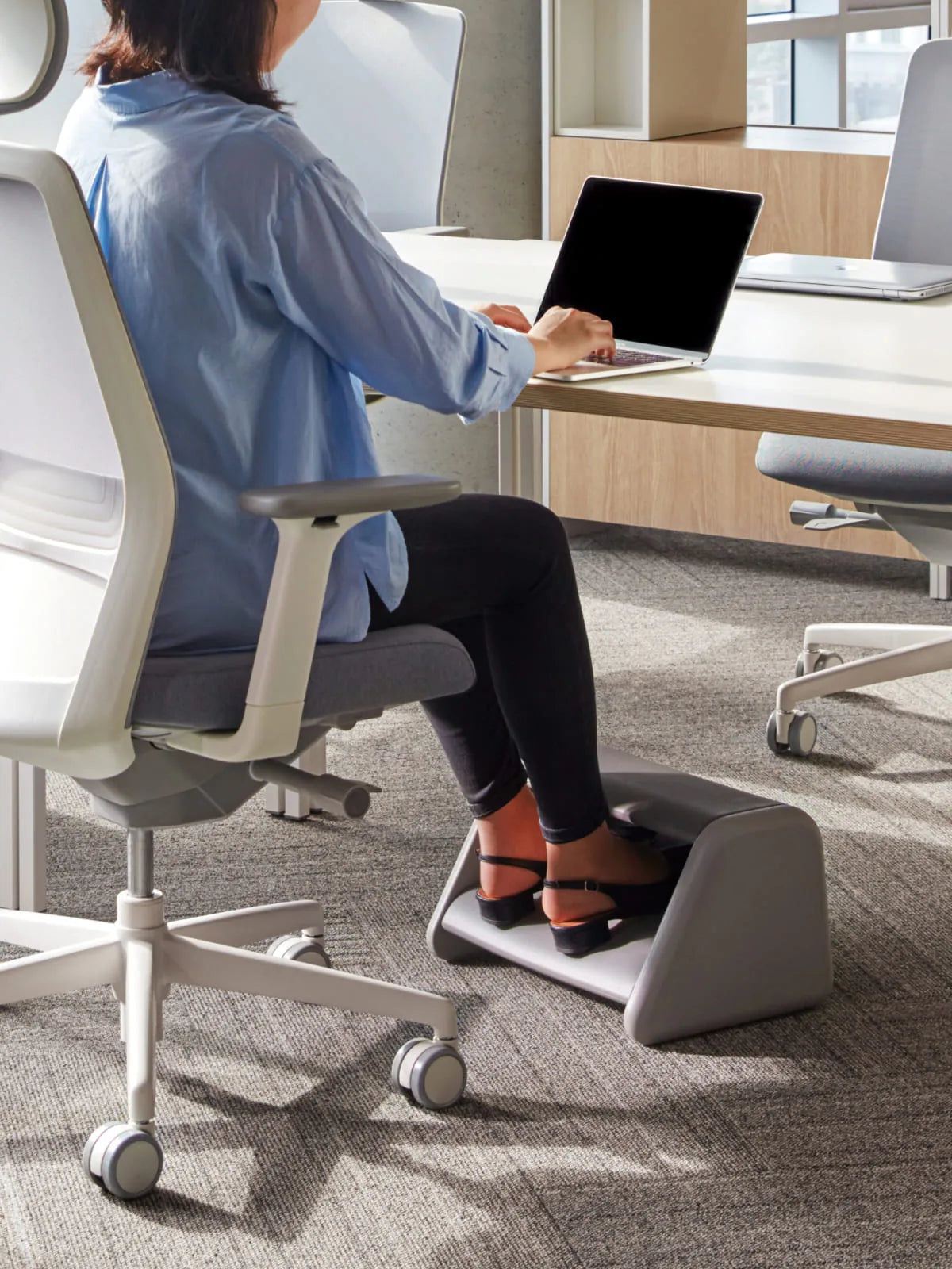 SIDIZ STEPO footrest supporting a seated work setup